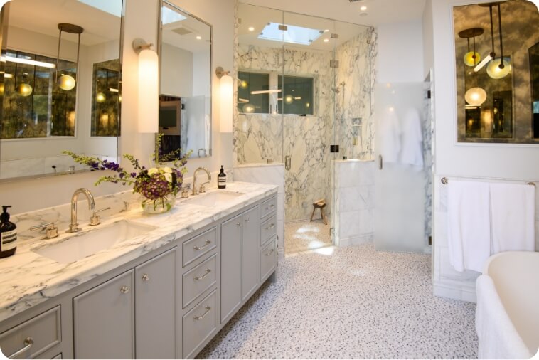 A stylish modern bathroom featuring marble countertops and elegant lighting.